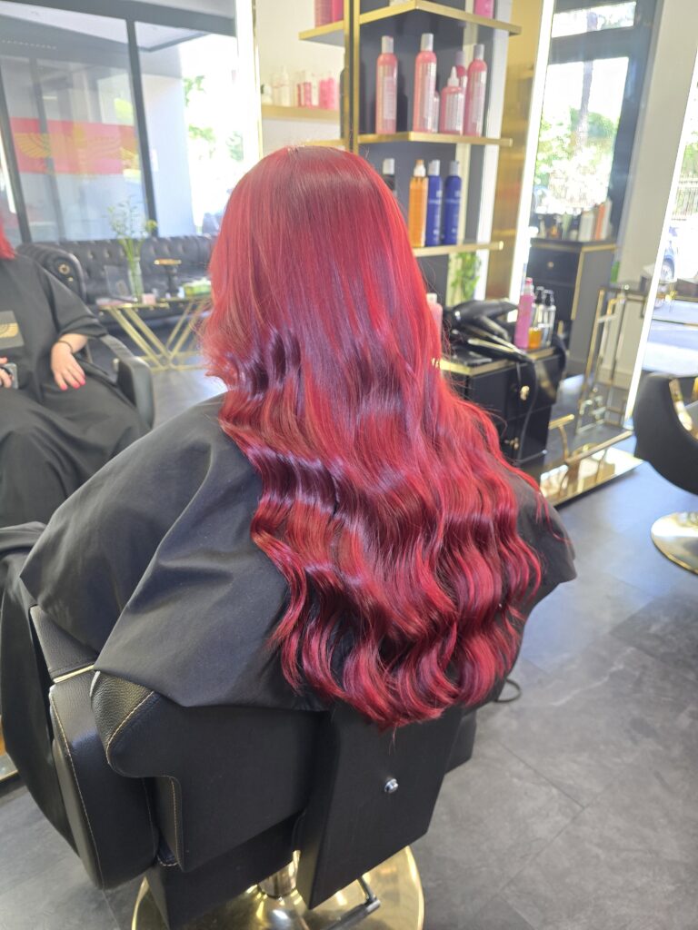 Donna con capelli lunghi e mossi, di colore rosso.