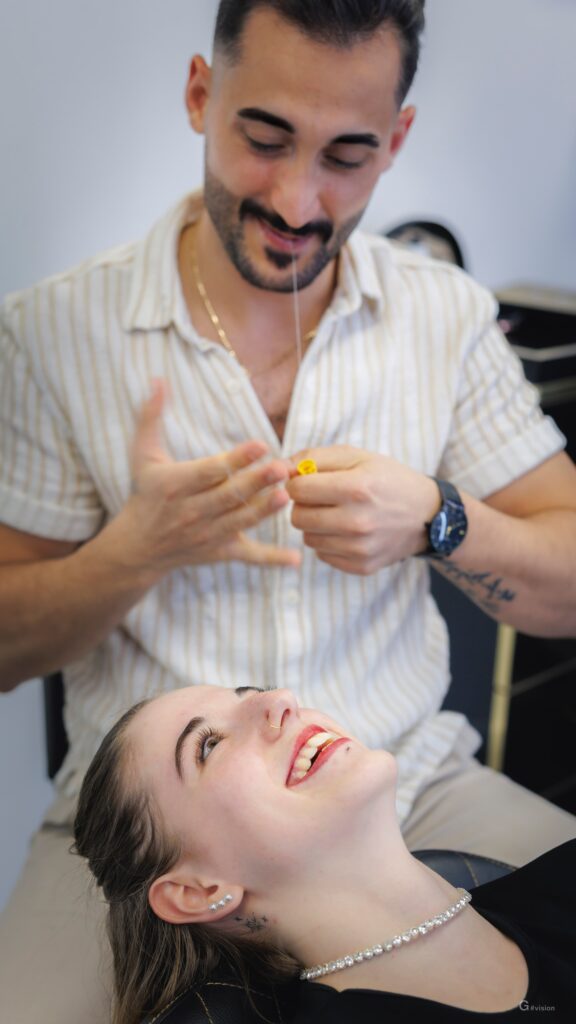 Professionista sorridente che prepara il filo per l'epilazione.