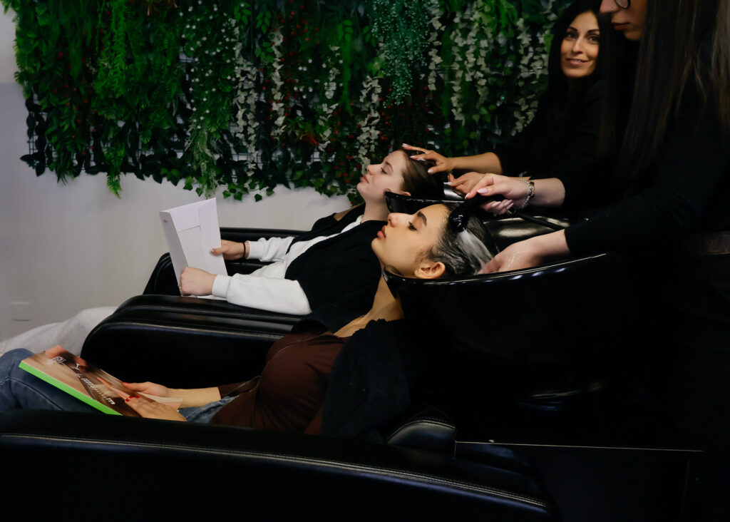Due donne che si fanno lavare i capelli in un salone.